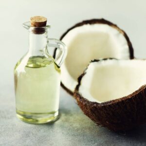 A coconut with a bottle of oil Description automatically generated