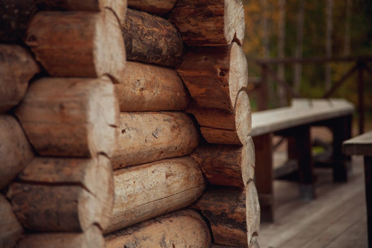 a stack of logs sitting on top of a wooden deck